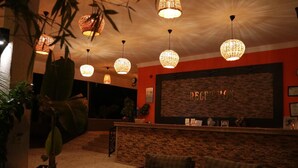 A reception area with wicker pendant lighting, a reception desk, and seating. - Taner Otel (Fethiye)