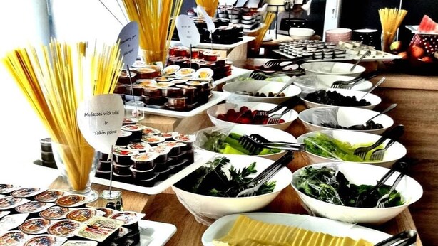 A buffet table with various food items including pasta, salads, and sliced meats. - Taner Otel (Fethiye)