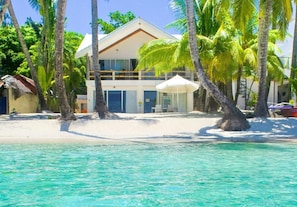 A beachfront property with a two-story building, a pool, and palm trees. - Mabuhay Beach House (Boracay Island)
