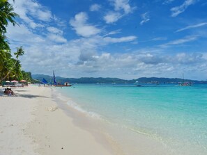 On the beach, white sand, sun-loungers, beach umbrellas