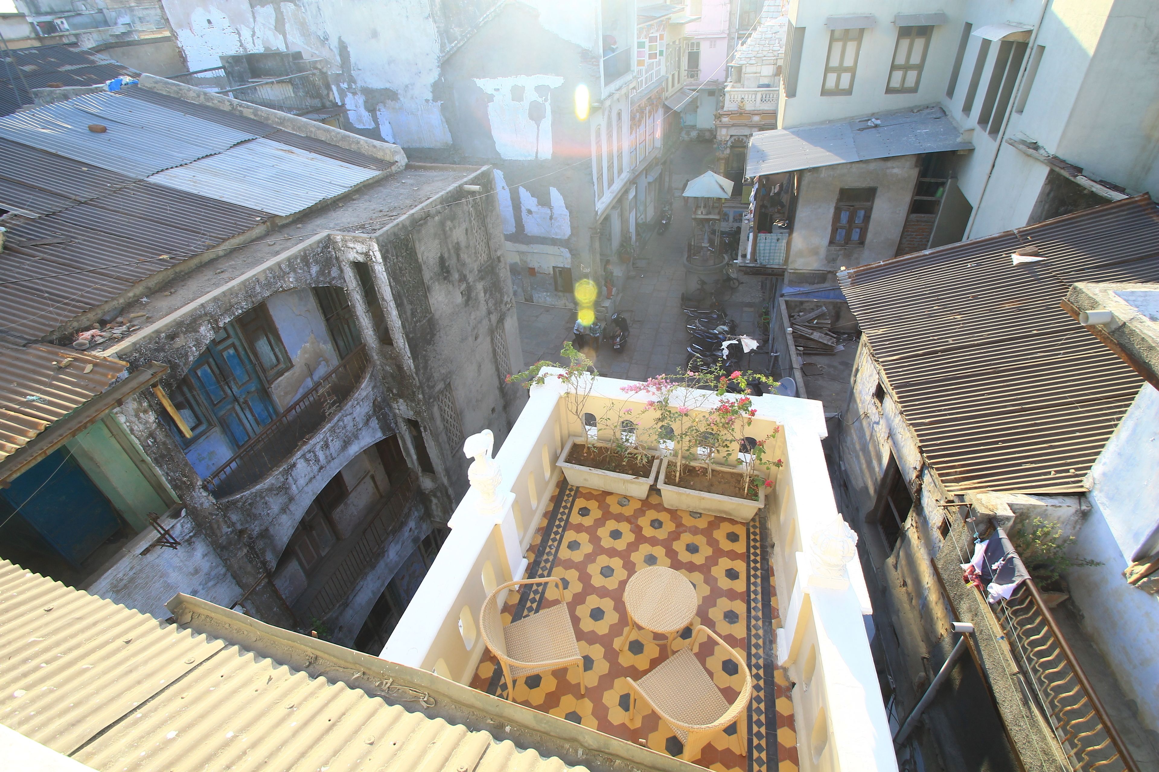 A courtyard with a patterned floor, two wicker chairs, and a small table.