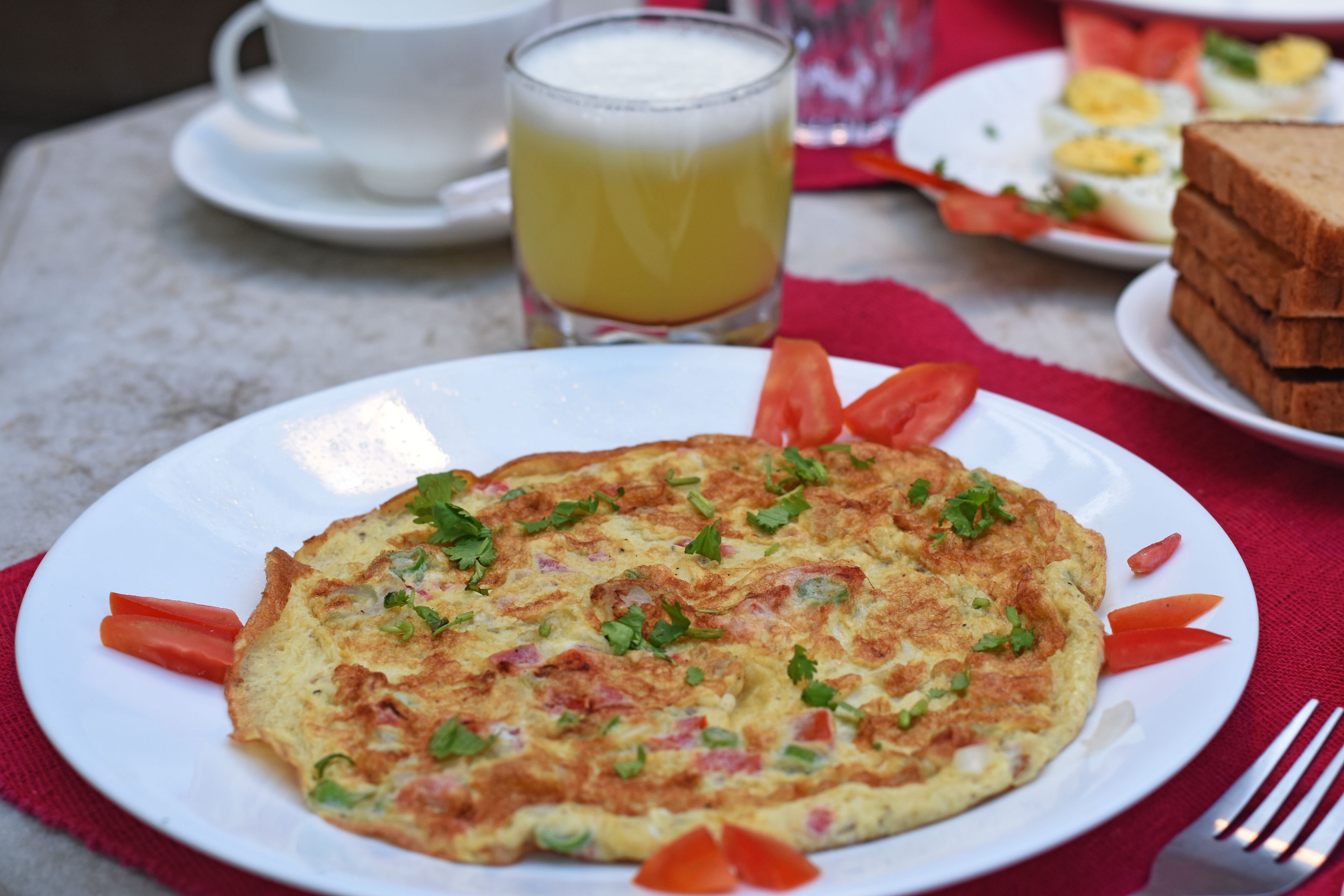 Ein Frühstücksteller mit einer Omelette, einem Glas Orangensaft und einer Toastplatte.