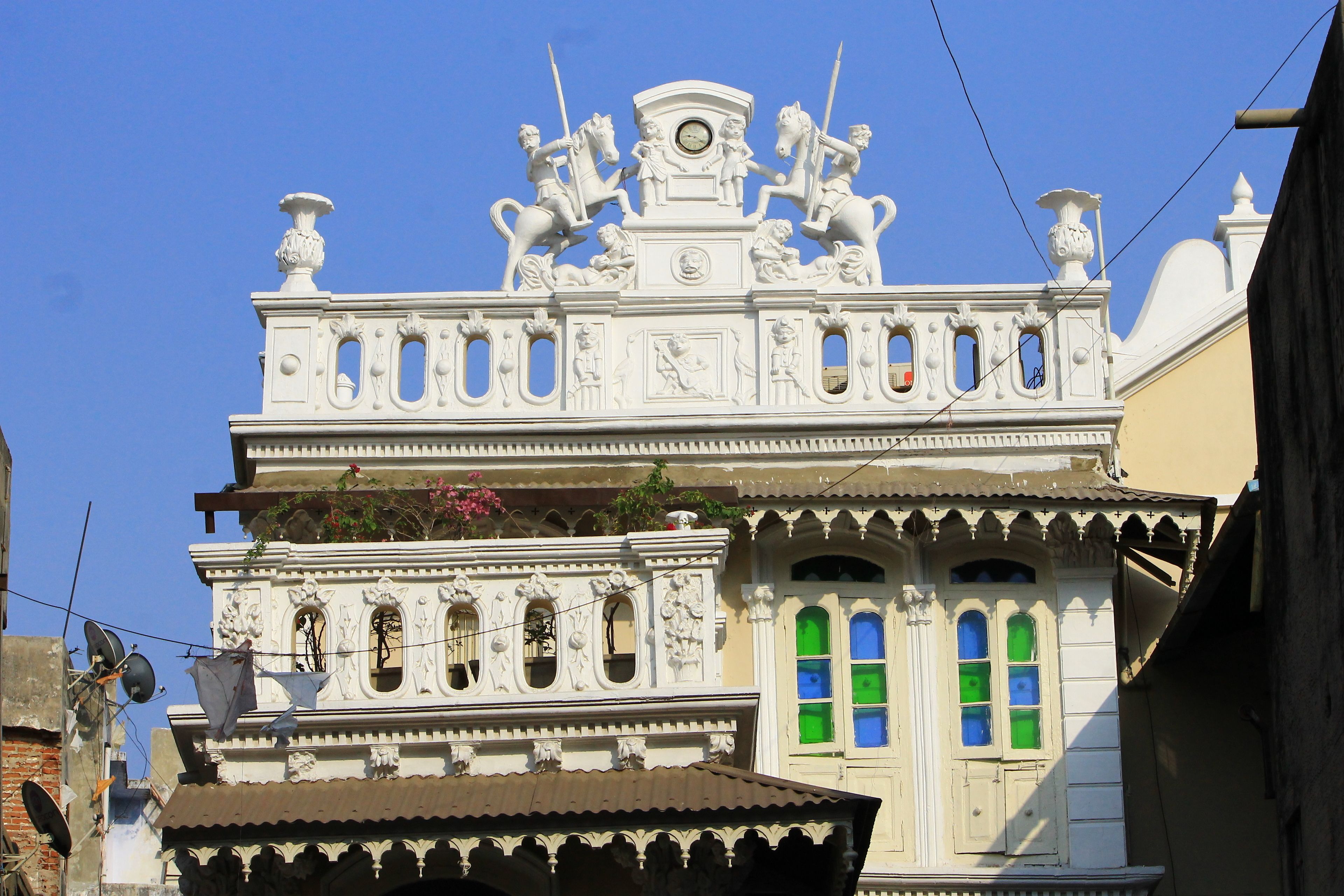 Un bâtiment doté d’éléments architecturaux raffinés, notamment des statues et des éléments décoratifs.