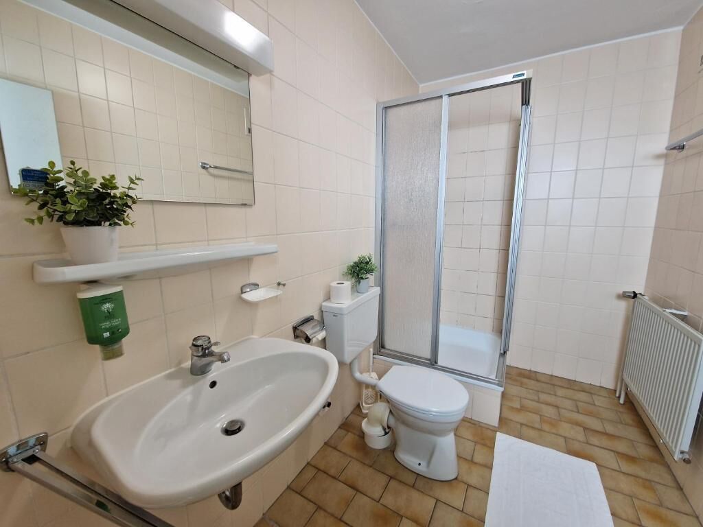 A bathroom with a sink, toilet, and shower.