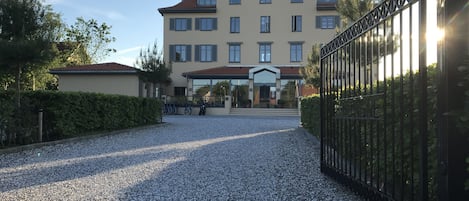 Un bâtiment avec une allée gravillonnée et une clôture en métal.