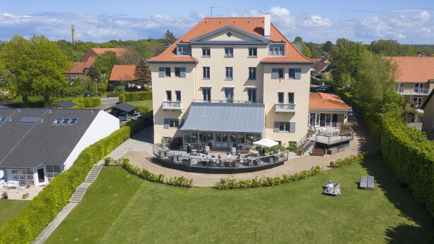 A multi-story building with a central courtyard, balconies, and a covered outdoor seating area.