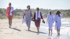 A group of people walking on a beach.