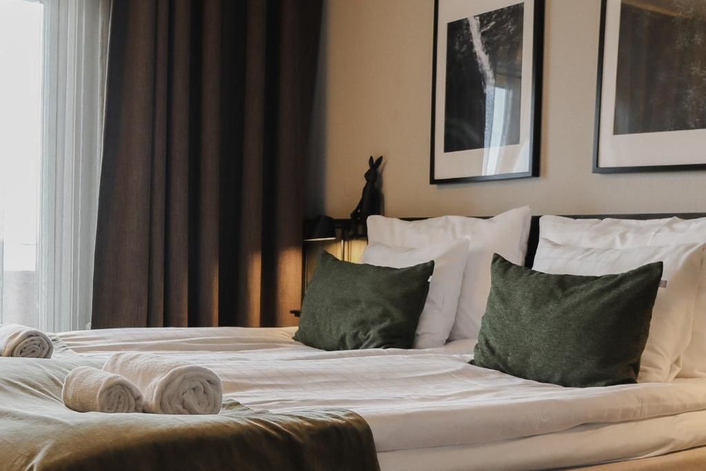 Una habitación de hotel con cama, almohadas, lámpara y cortinas.