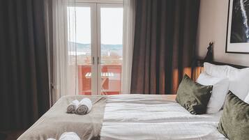 Escritorio, cortinas blackout y tabla de planchar con plancha