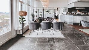 Un interior moderno con una zona de estar, un bar y ventanas amplias.