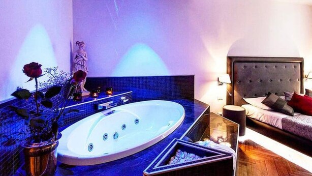 Une salle de bain moderne avec une grande baignoire, un petit lavabo et une statue.