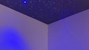 Une salle de spa moderne avec un jacuzzi, une petite table sur laquelle est posée une bougie et un vase décoratif.