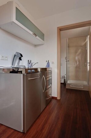 A modern kitchen with stainless steel appliances, a built-in microwave, and a coffee maker. - Pension Haselmann (Münster)