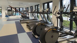 A gym with treadmills, elliptical machines, and a rowing machine. - Peel Park Quarter - Campus Accommodation (Salford)