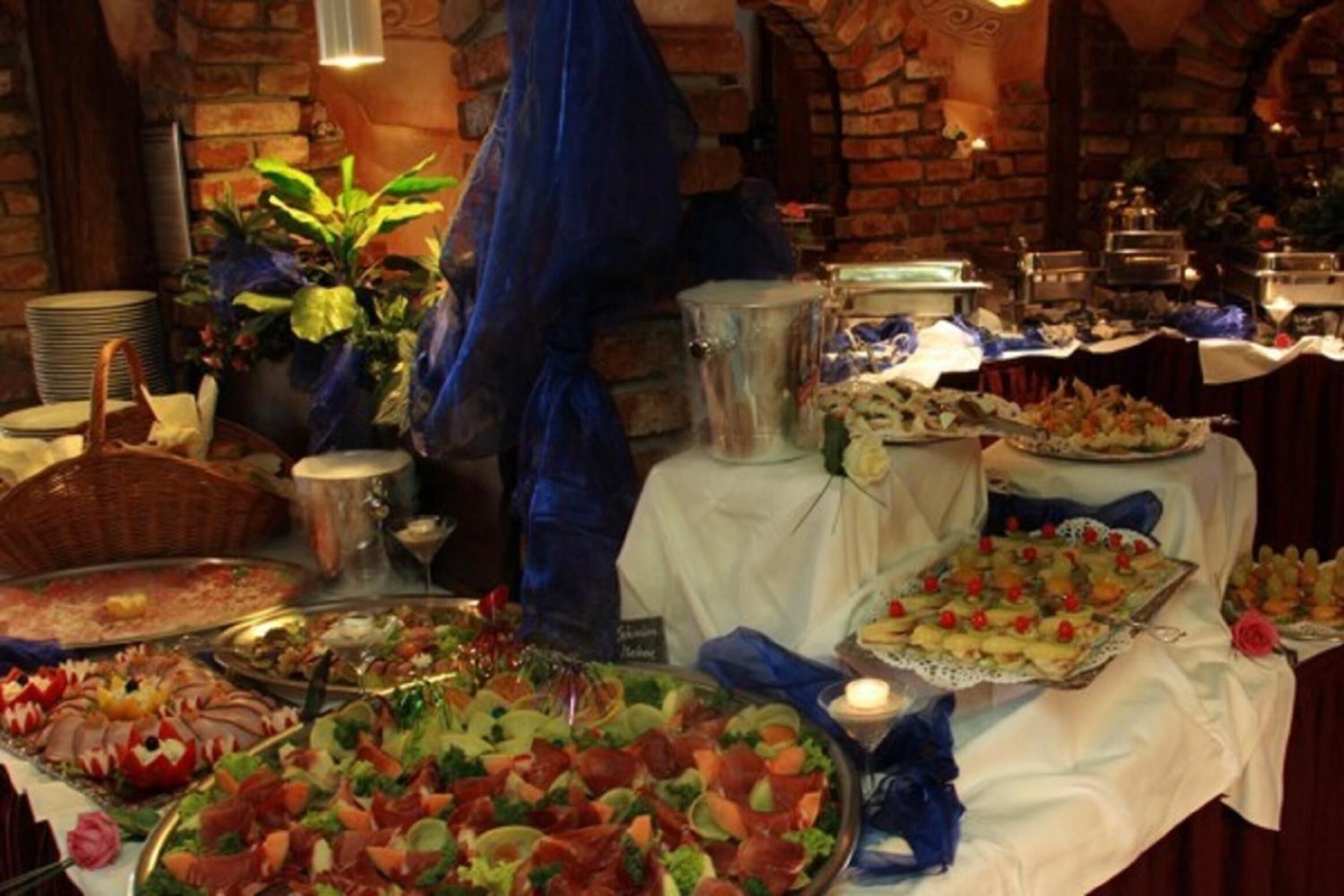 Un bufé con diversos alimentos y una vela sobre la mesa.