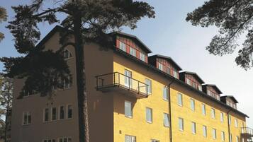 Un edificio de varios pisos con balcones, ventanas amplias y techo plano.