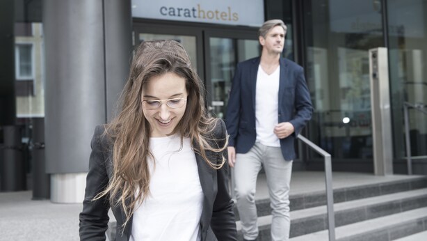 Een modern gebouw met een bord waarop 'carathotels' staat.