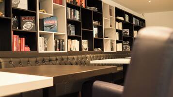 Una biblioteca con estanterías, una zona de estar y una mesa.