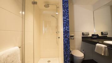 A modern bathroom with a glass-enclosed shower, a white toilet, and a black countertop with a sink.
