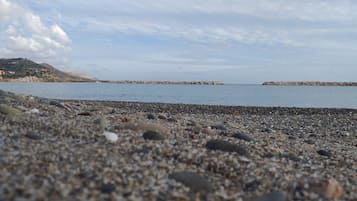 På stranden, hvidt sand, liggestole, badehåndklæder