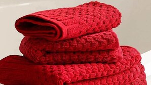 A stack of red towels placed on a white bathtub. - Pension Balerdi (San Sebastián)
