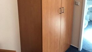 A wooden wardrobe with two doors and a handle on the left. - Hotel Montan (Duisburg)