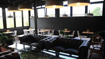 Un intérieur moderne avec des canapés en cuir, des tables en verre et des luminaires suspendus.