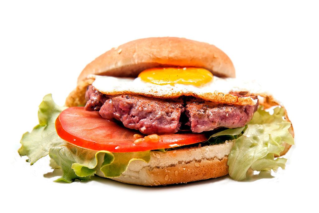 Un panino farcito con uovo fritto, carne, pomodoro e lattuga.