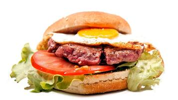 Un panino farcito con uovo fritto, carne, pomodoro e lattuga.