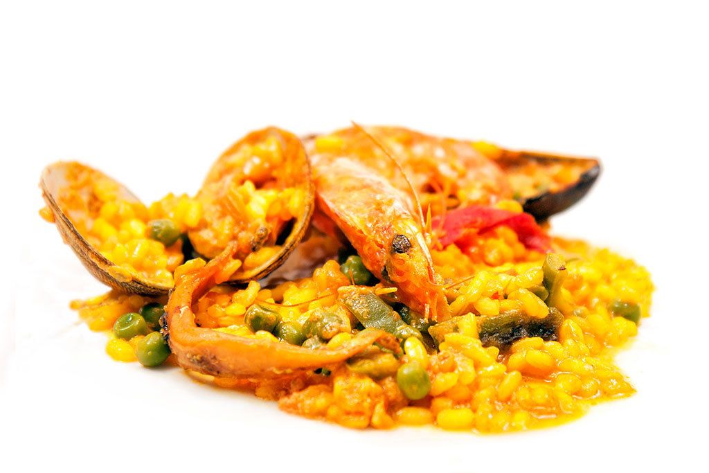 A dish of seafood paella with mussels and peas.