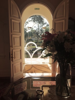 An open doorway with a sign reading "SALIDA" leading to an outdoor area with a white decorative structure and a garden view. - Hotel Alquimista Montevideo (Montevideo)