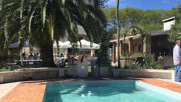 Una piscina al aire libre, sillones reclinables de piscina