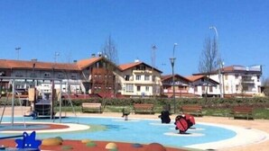A hotel with a swimming pool, outdoor seating, and a playground area. - HOSTAL EUROPA pensión (Irun)
