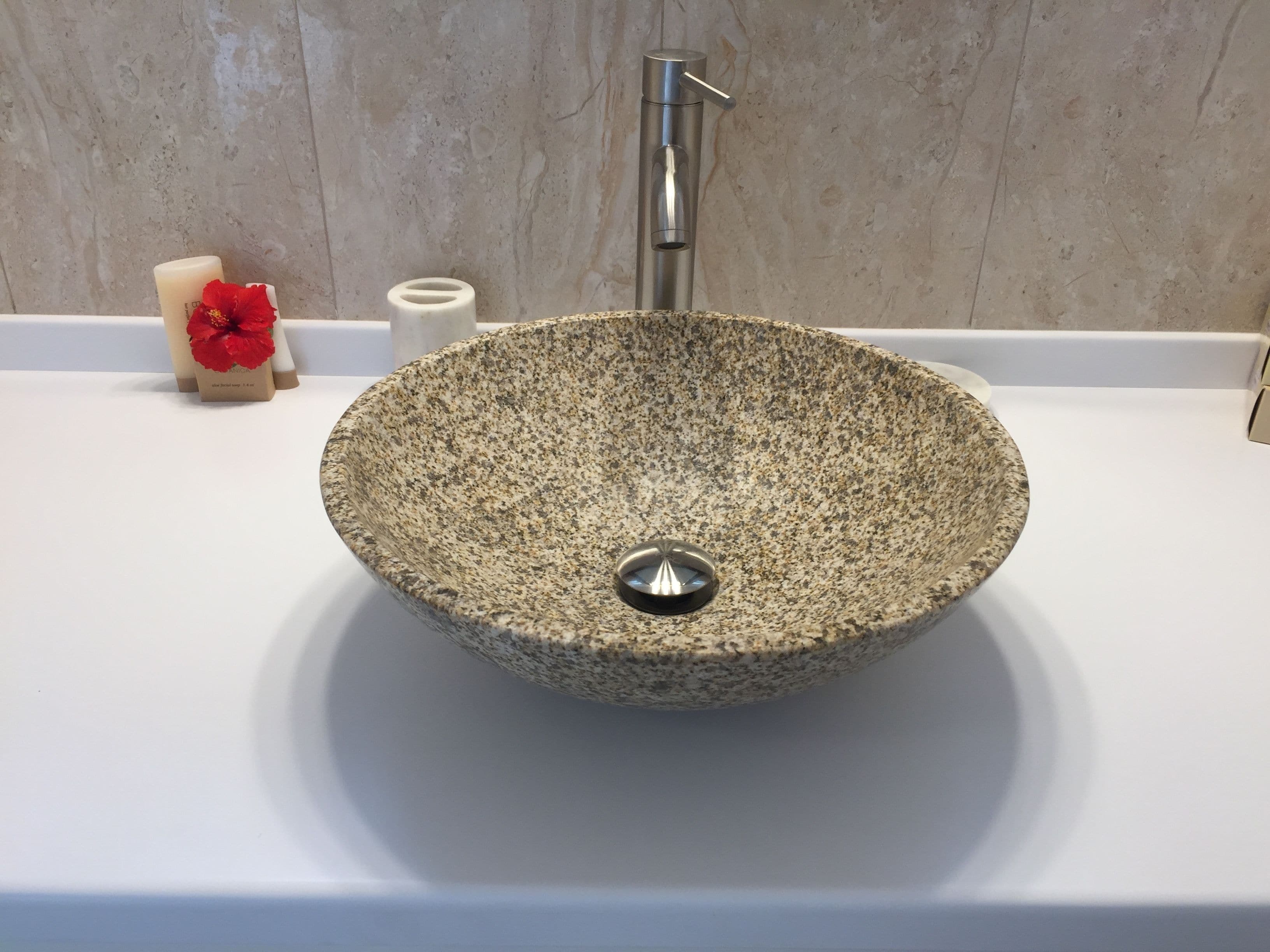 A stone sink with a faucet in a bathroom.