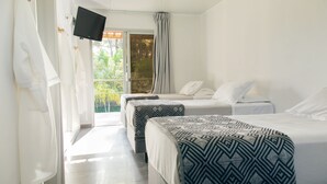A hotel room with two beds, a TV, and a balcony with a view of greenery. - Undarius Hotel - Clothing Optional Hotel Exclusively for Gay Men (Chihuahua)