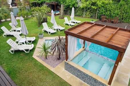 Una piscina al aire libre de temporada, sombrillas