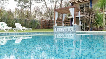 Una piscina al aire libre de temporada, sombrillas