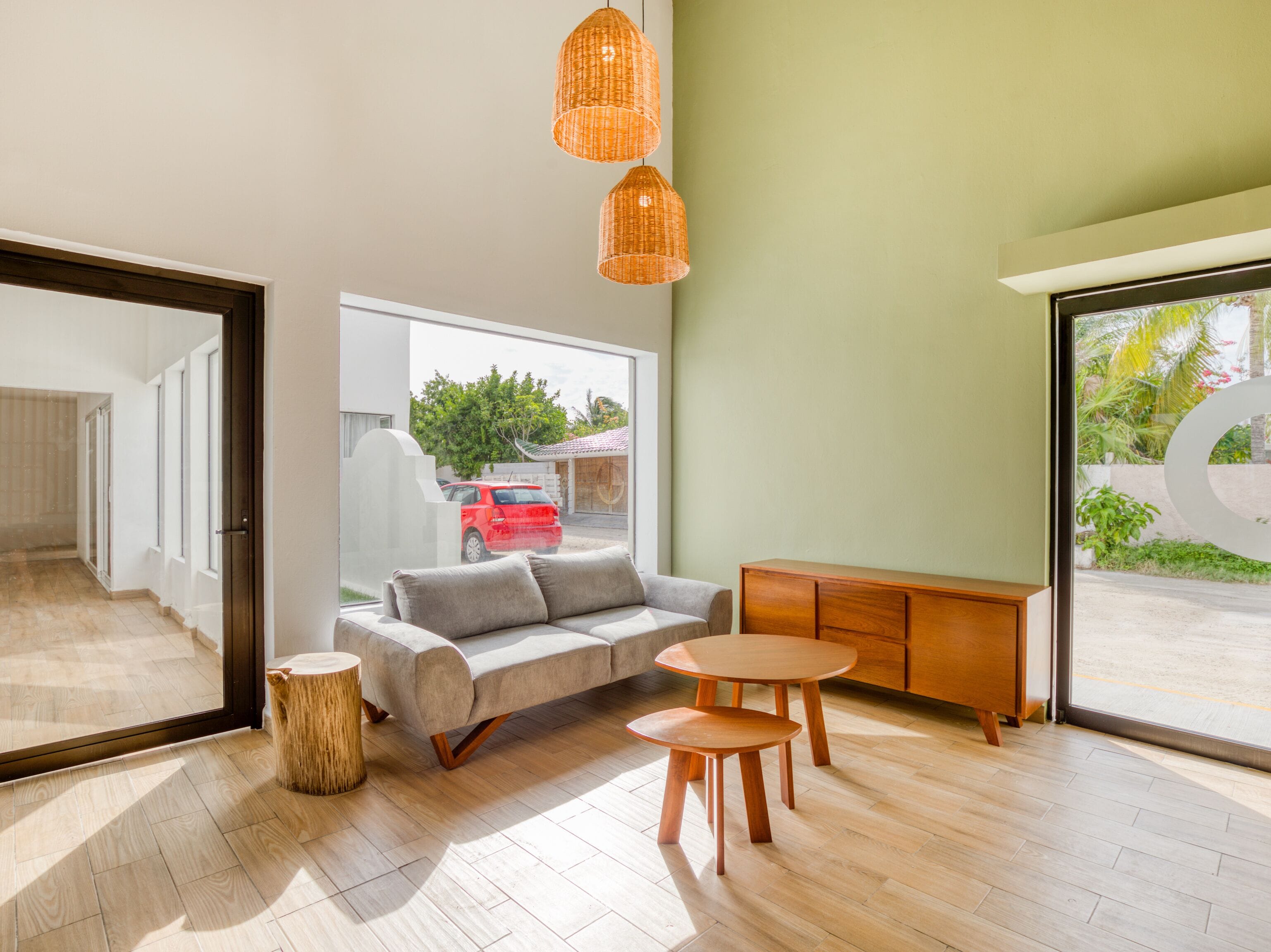 Una sala de estar moderna con un sofá, dos mesas de madera y un mueble de madera.
