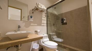 A bathroom with a sink, toilet, and glass-enclosed shower.