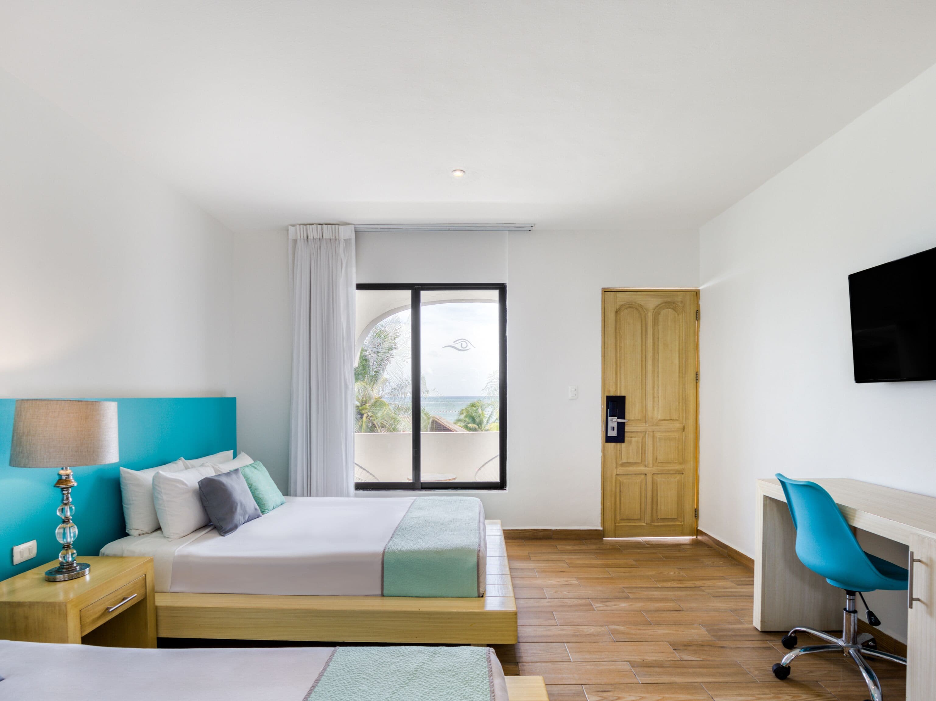 A bedroom with a bed, a desk, and a chair.