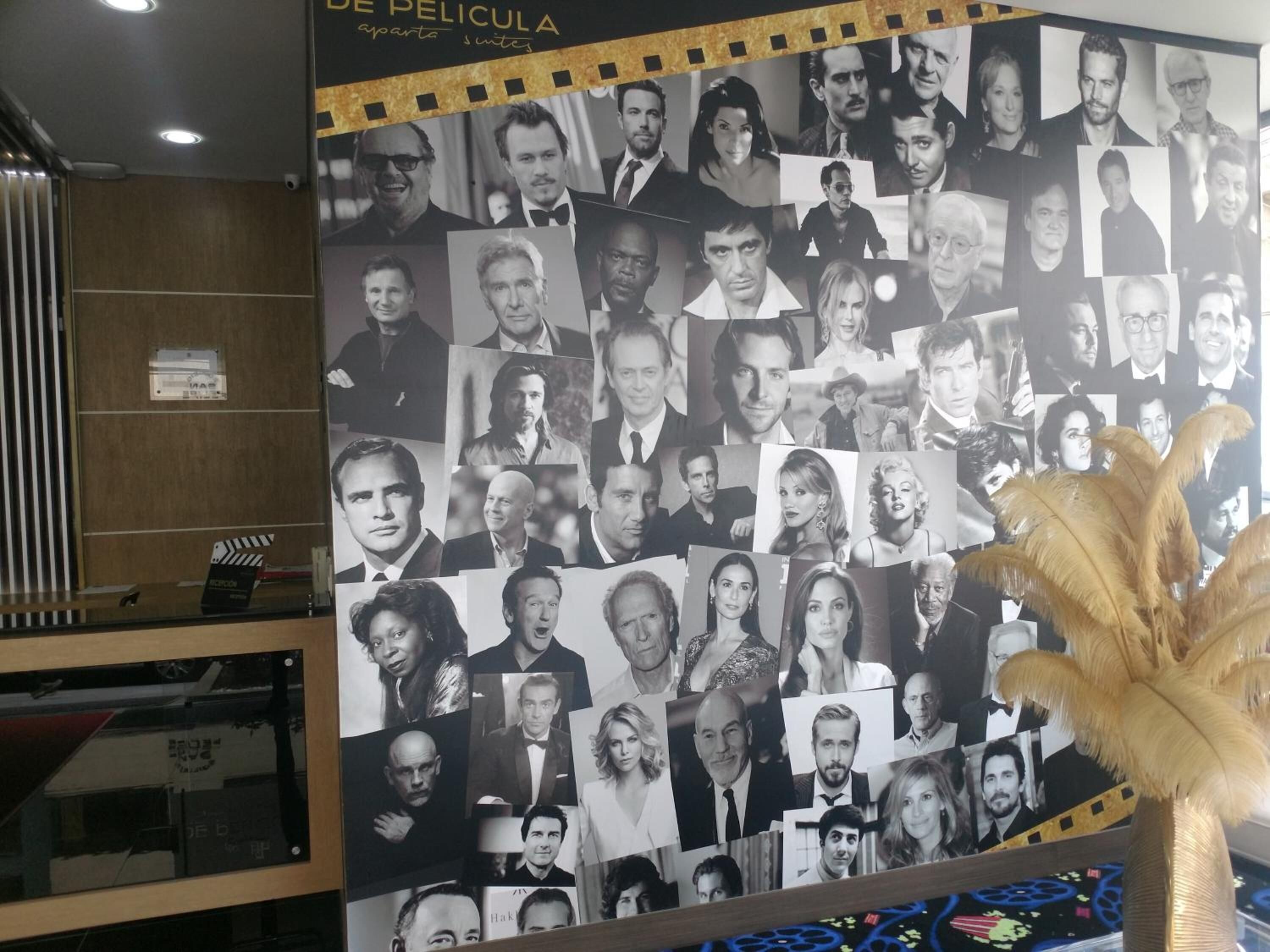 Una pared con numerosas fotografías en blanco y negro de personas, posiblemente actores o personalidades del cine, dispuestas en un collage.