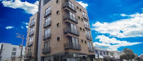 A multi-story building with balconies and large windows.