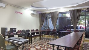 A conference room with a long table, chairs, a keyboard, and a "No Smoking" sign. - RedDoorz Plus near Stadion Mandala Krida (Yogyakarta)