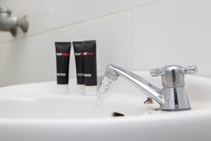 Sink with chrome faucet and toiletries.