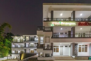 Un hotel de varios pisos con balcones y un letrero de casa de huéspedes.