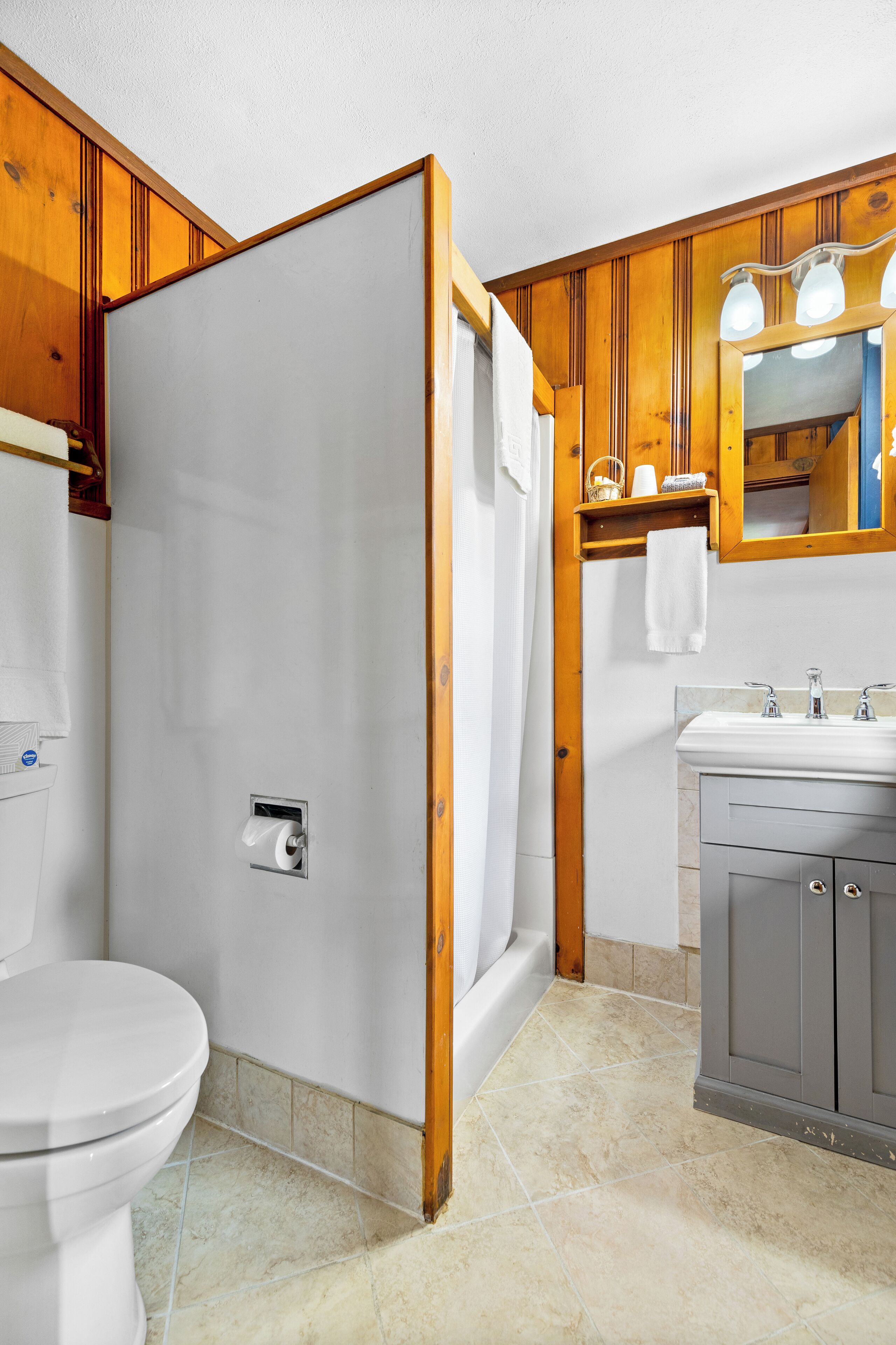 Un baño con inodoro, ducha y lavamanos.