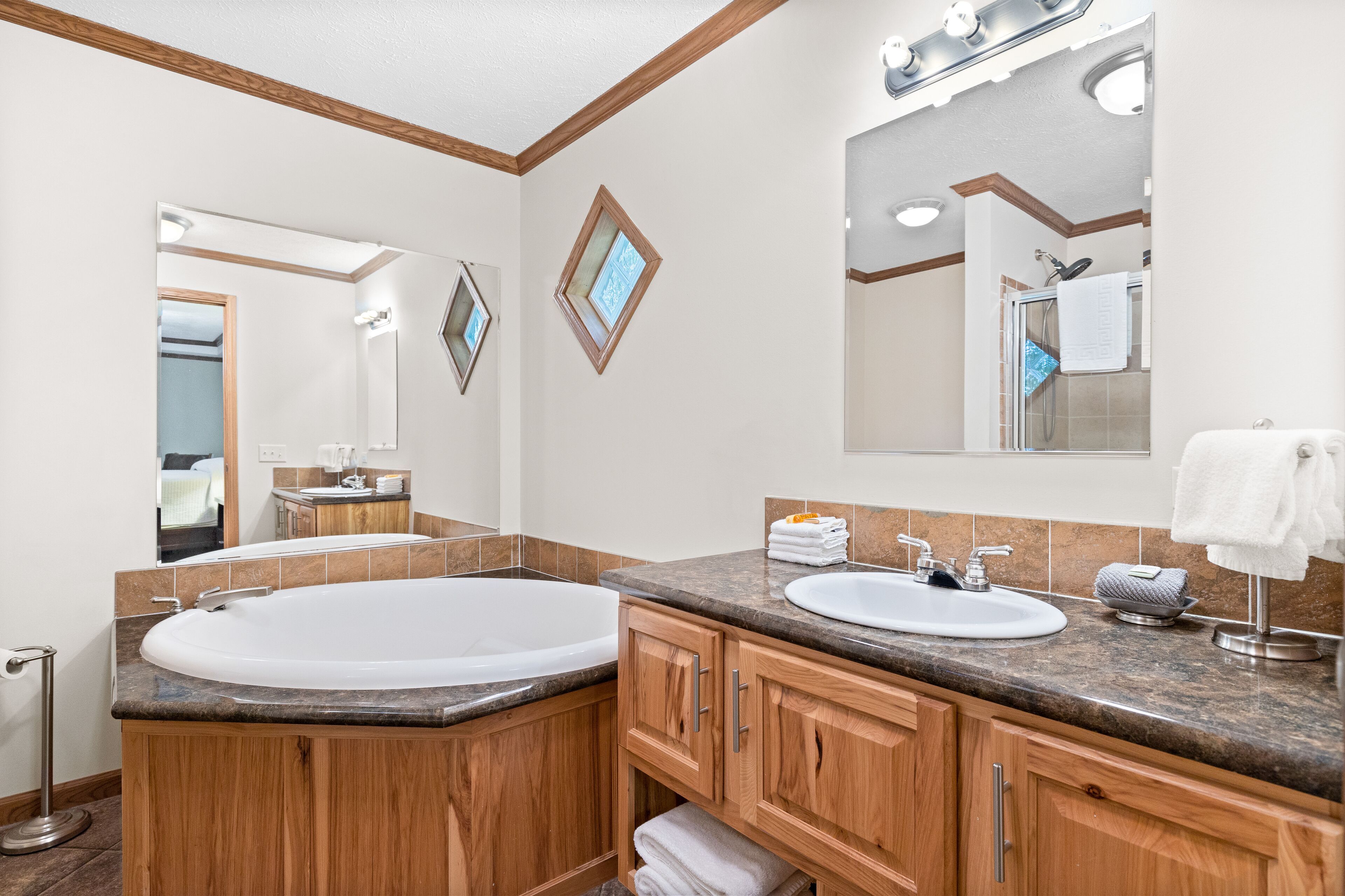 A modern bathroom with a large freestanding bathtub, a sink, and a vanity with a mirror.