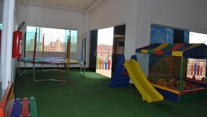 Ein Spielbereich mit Trampolin, Rutsche und Bällebad.