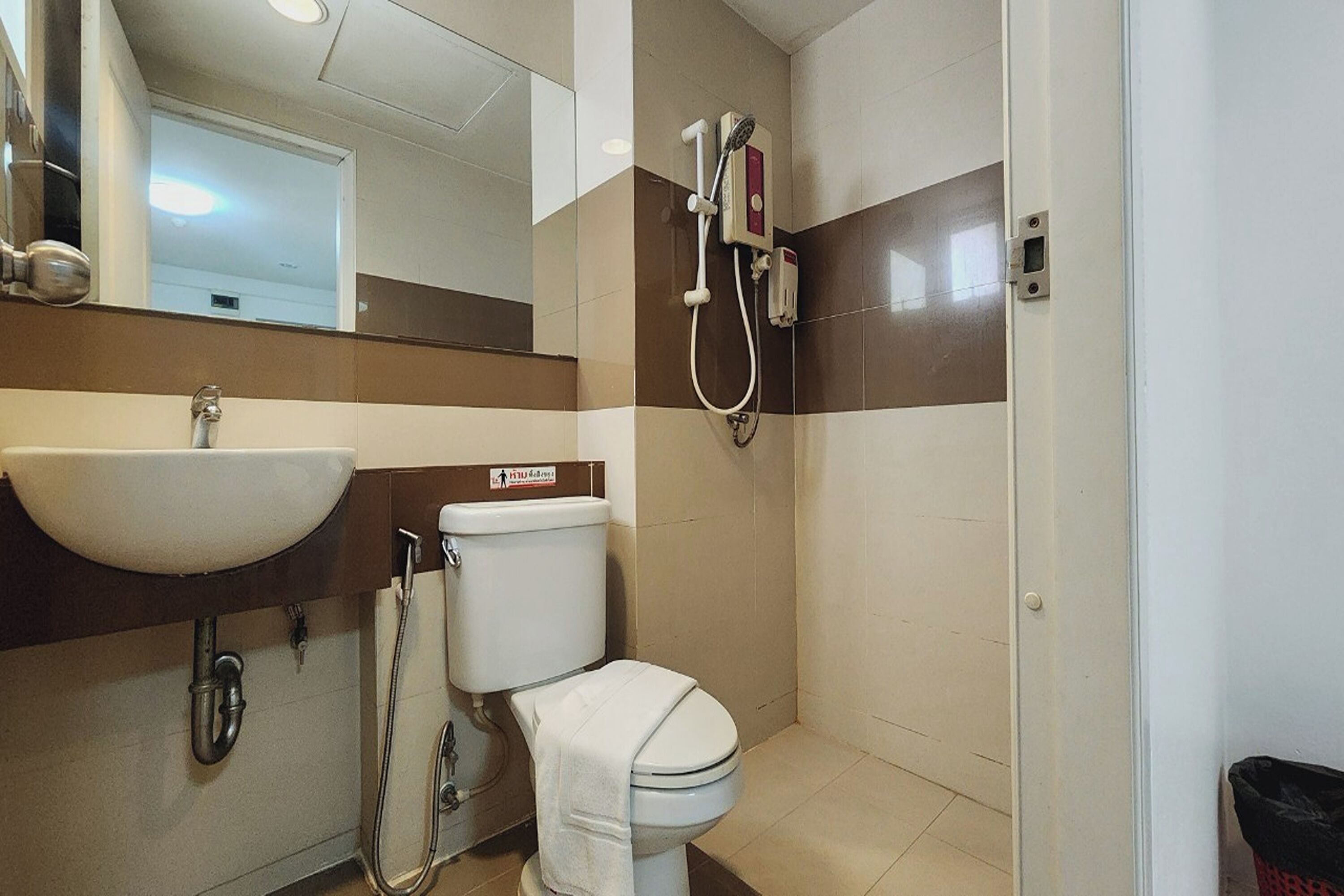 Un baño con lavamanos, inodoro y ducha.