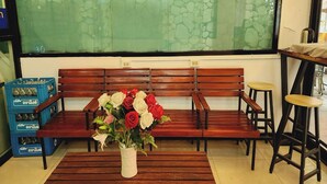 A wooden bench with a vase of flowers in front. - Zenith Life (Nonthaburi)